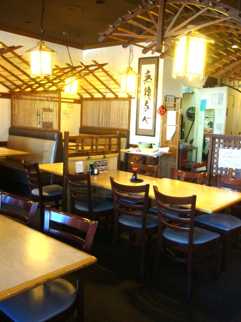 Interior view of a Ojiya restaurant located in Chino Hills, featuring wooden tables, chairs, and traditional decorative elements, creating a warm and inviting atmosphere.
